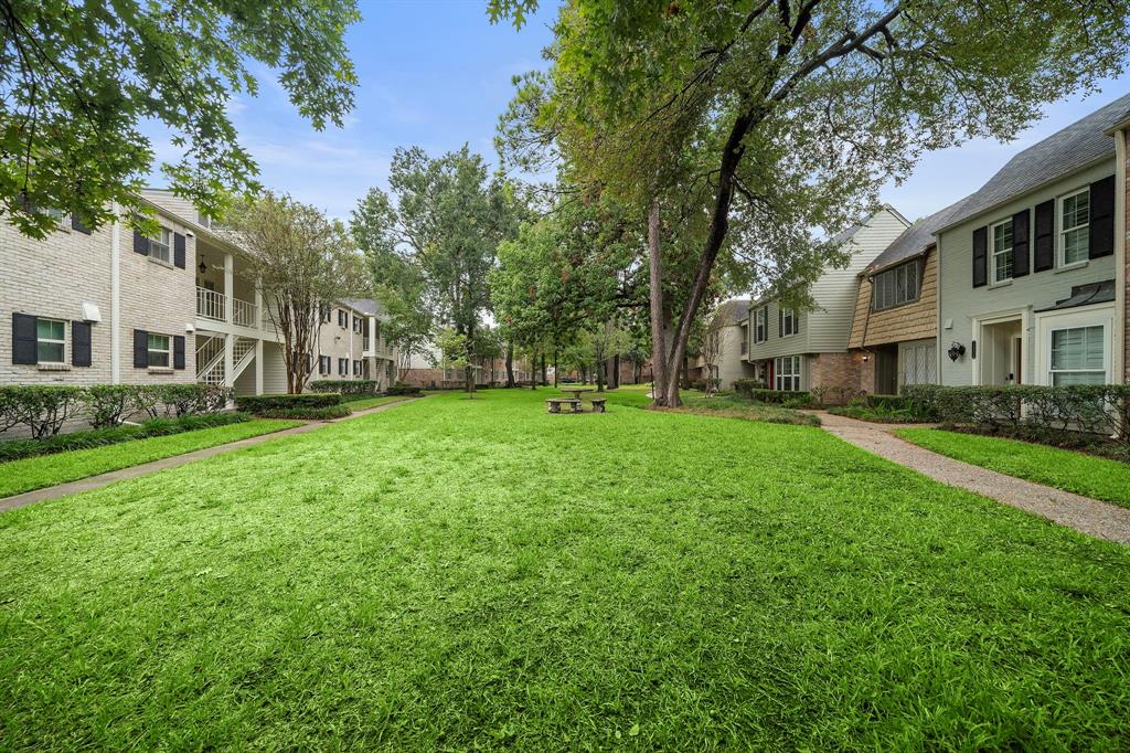 13006 Trail Hollow Drive, Unit A Houston, TX 77079 - Photo 1 of 18 a view of a house with a big yard and large trees