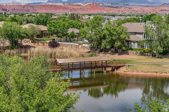 2608 Canyon Ridge Drive St. George, UT 84770 - Photo 54 of 86 Expansive landscape featuring a covered wooden bridge spanning a body of water, surrounded by green trees and natural foliage