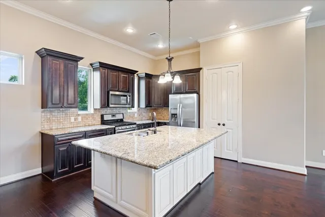 a kitchen with stainless steel appliances granite countertop a sink stove and refrigerator