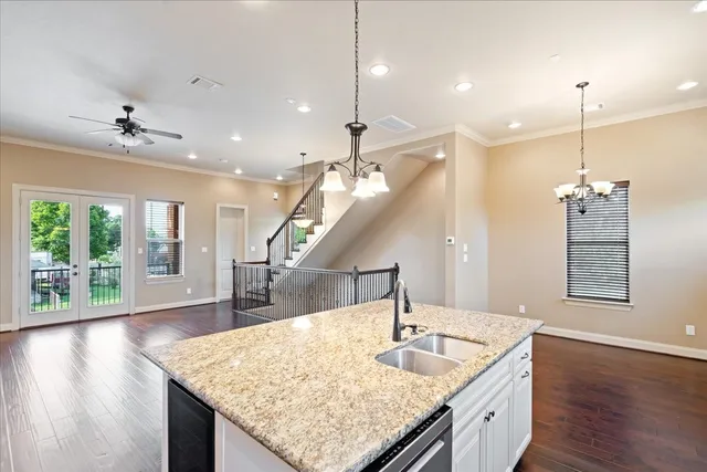 a kitchen with center island chandelier and wooden floor