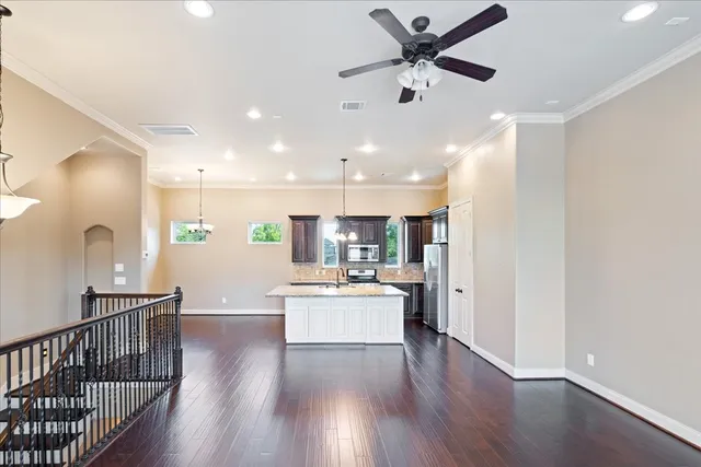 a living room with stainless steel appliances kitchen island furniture and wooden floor
