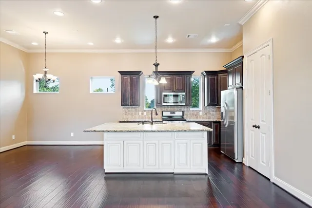 a kitchen with stainless steel appliances granite countertop a sink a stove and refrigerator