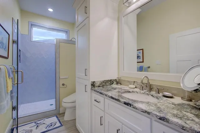 a bathroom with a granite countertop sink toilet and shower