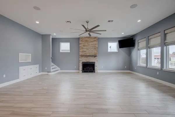 a view of an empty room with a fireplace and a window