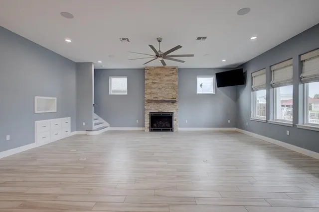 a view of an empty room with a fireplace and a window