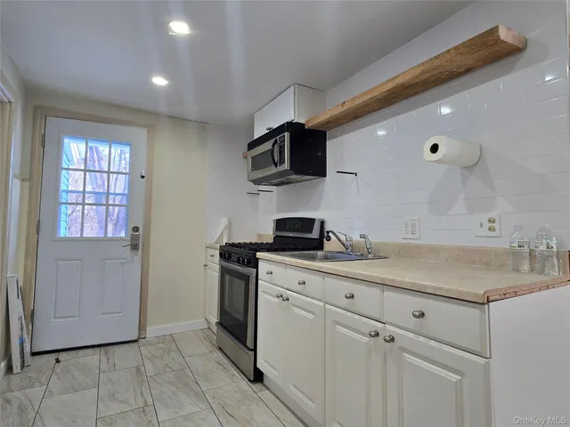 a kitchen with stainless steel appliances granite countertop a sink and a stove