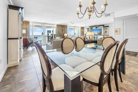 a dining room with furniture a chandelier and wooden floor
