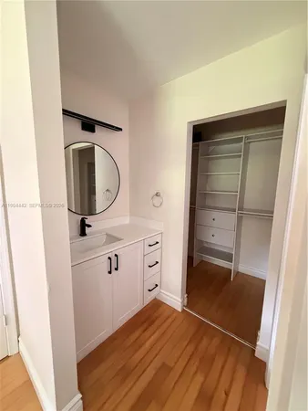 a hallway with white cabinets and white appliances