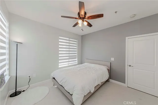 a bedroom with a large bed and a ceiling fan