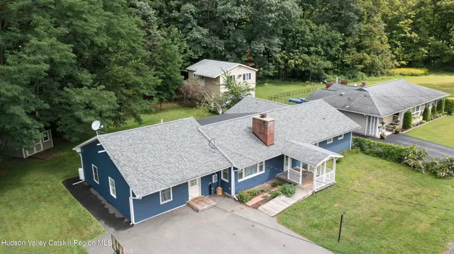 an aerial view of a house with swimming pool and yard with green space