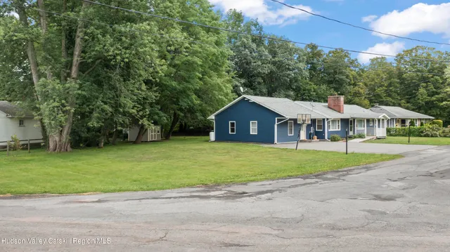 a front view of a house with a yard and trees