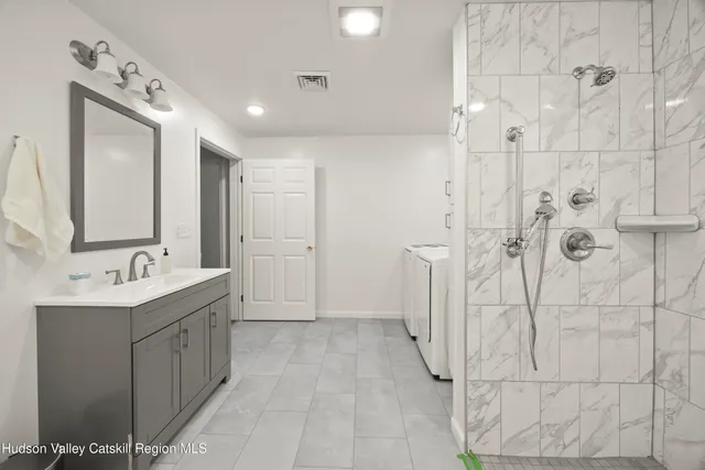 a bathroom with a double vanity sink mirror and shower
