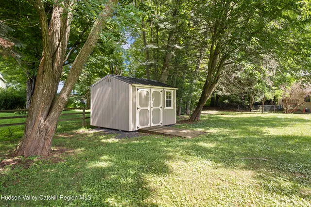 a view of a house with backyard and a tree