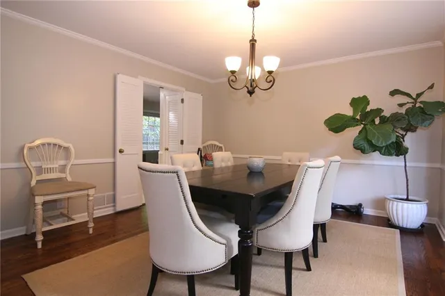 a view of a dining room with furniture a chandelier and wooden floor