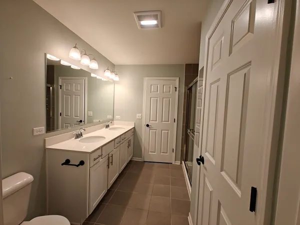 a bathroom with a double vanity sink mirror and toilet