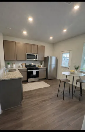 a kitchen with stainless steel appliances granite countertop a stove top oven a sink dishwasher and a refrigerator