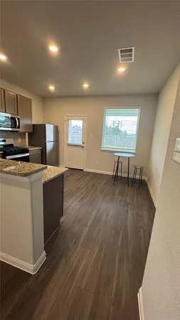 a view of kitchen with wooden floor and electronic appliances