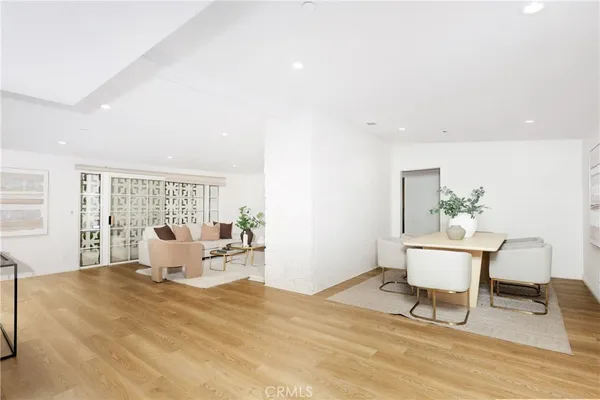 a living room with a couch and dining table with wooden floor