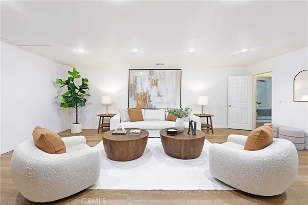 a living room with furniture potted plant and a large window