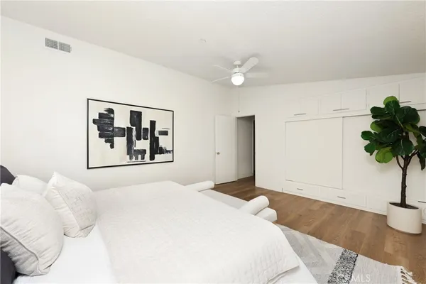 a bedroom with a large bed and a potted plant
