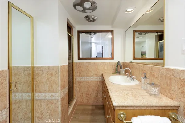a bathroom with a granite countertop sink a mirror and a shower