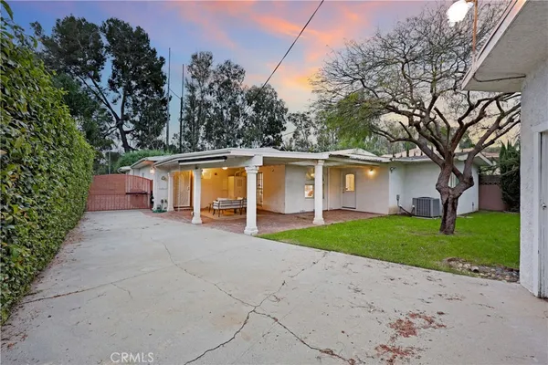 a view of a house with backyard and a tree
