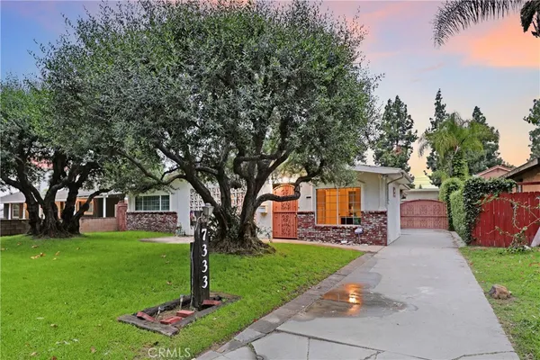 a front view of a house with a yard and trees