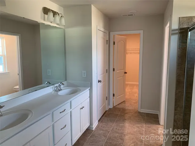 a spacious bathroom with a granite countertop sink a mirror and a