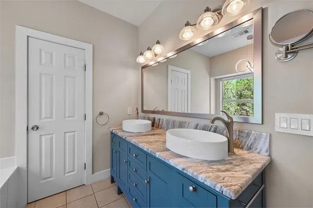 a bathroom with a granite countertop sink and a mirror
