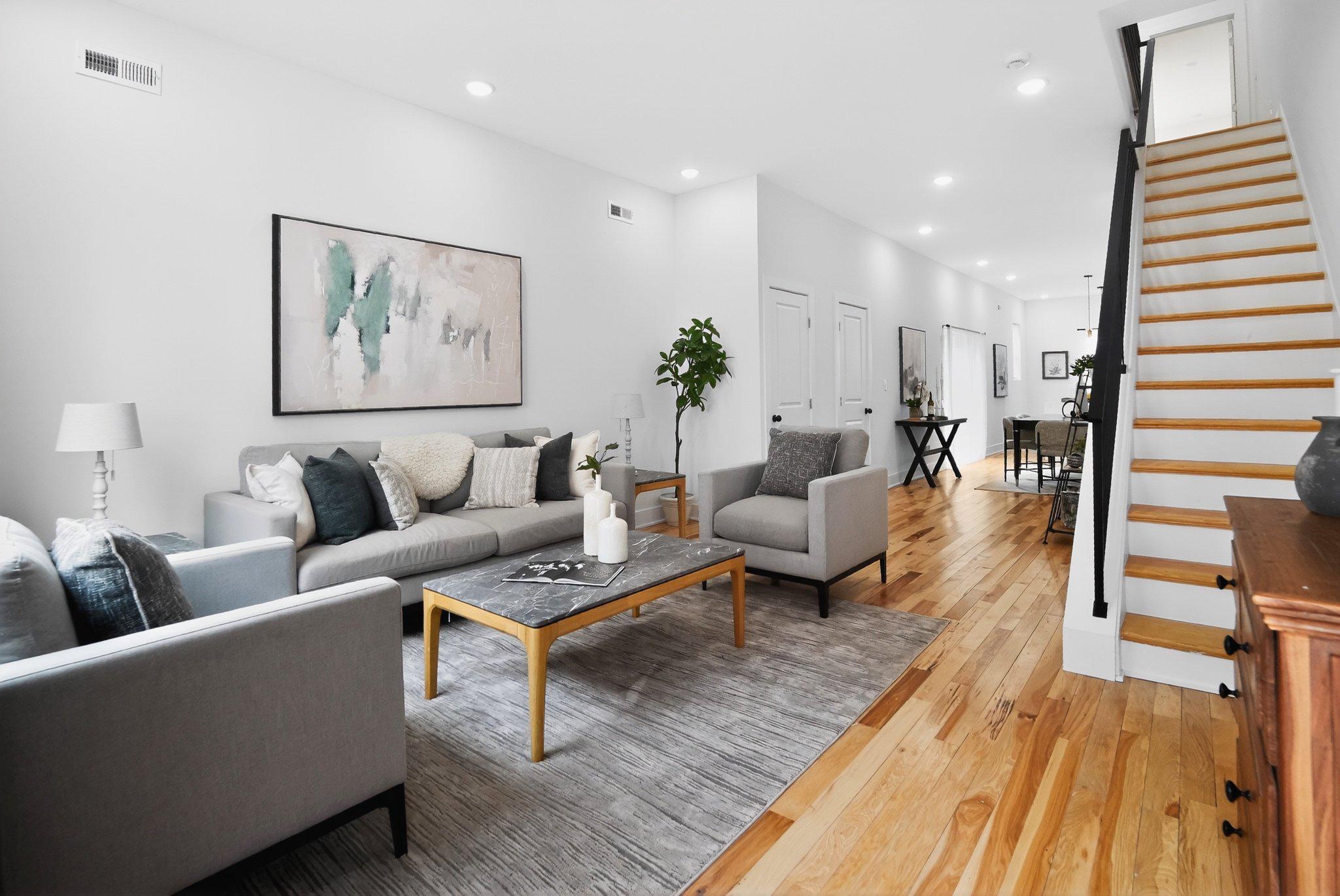 a living room with furniture and wooden floor