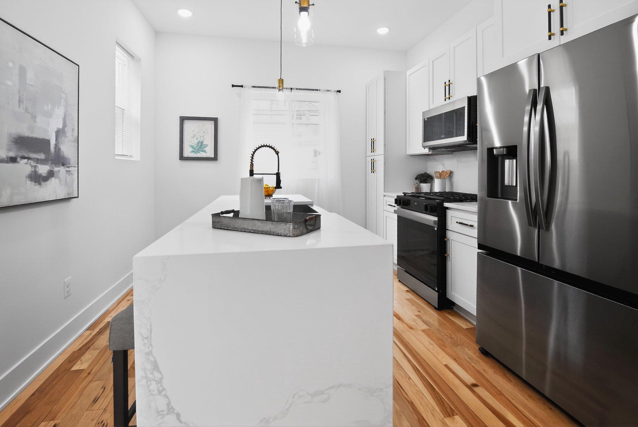 1314 South 46th Street Philadelphia, PA 19143 - Photo 4 of 56 a kitchen with kitchen island a refrigerator sink and stove