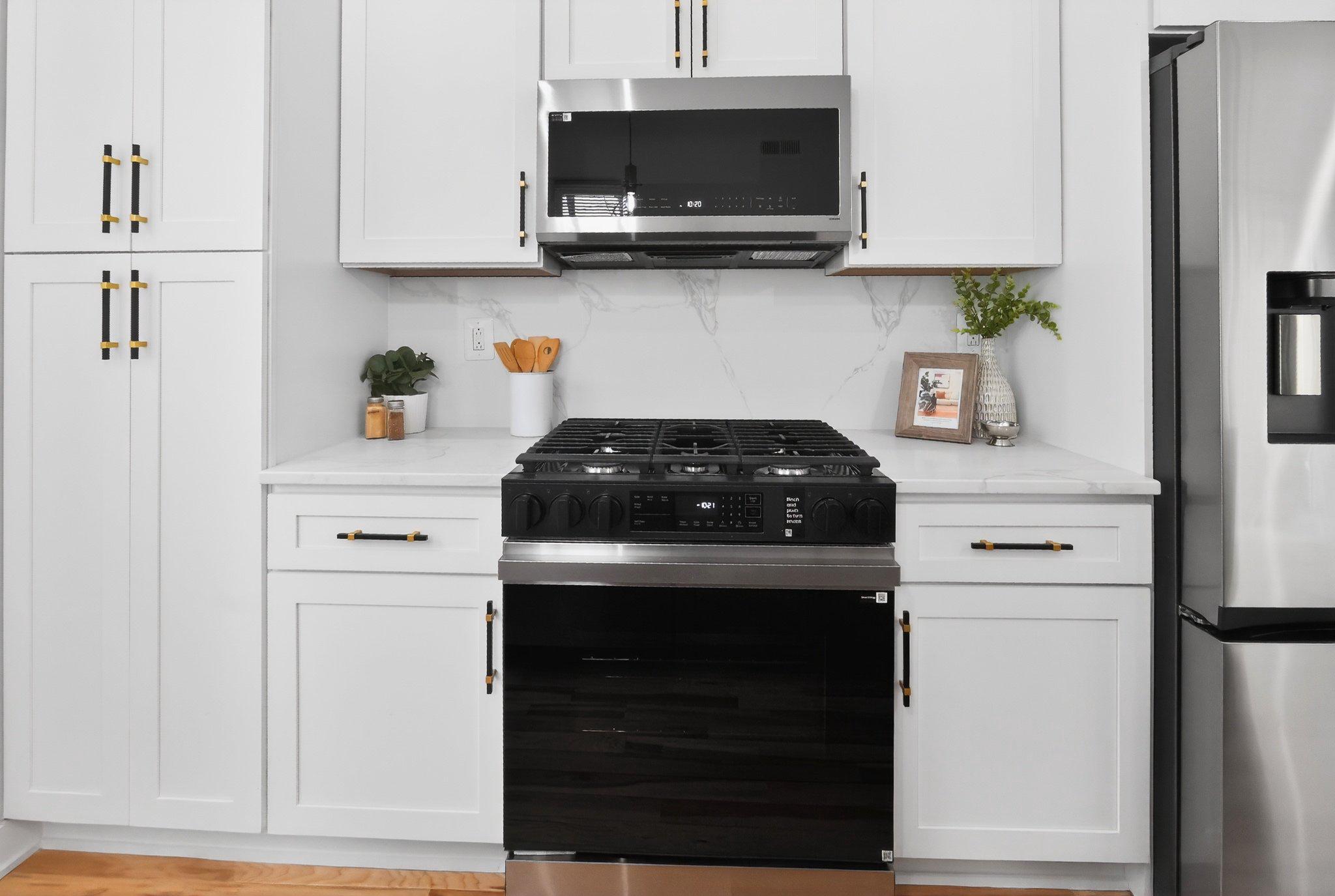 1314 South 46th Street Philadelphia, PA 19143 - Photo 7 of 56 a kitchen with stainless steel appliances granite countertop white cabinets and a stove