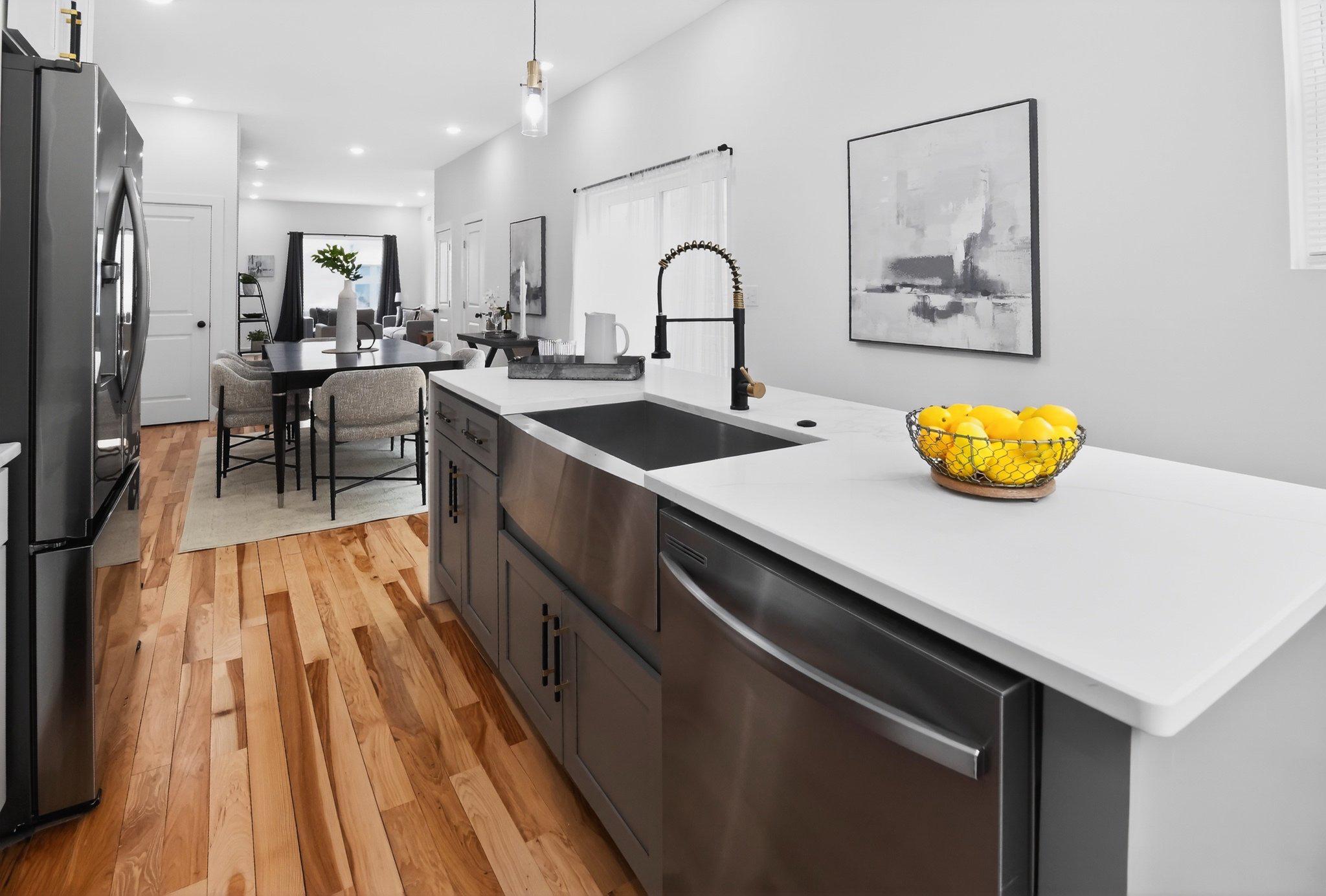 1314 South 46th Street Philadelphia, PA 19143 - Photo 8 of 56 a kitchen with stainless steel appliances granite countertop a stove a sink and a dining table with wooden floor
