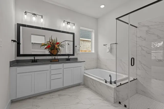 a bathroom with a tub a sink and mirror