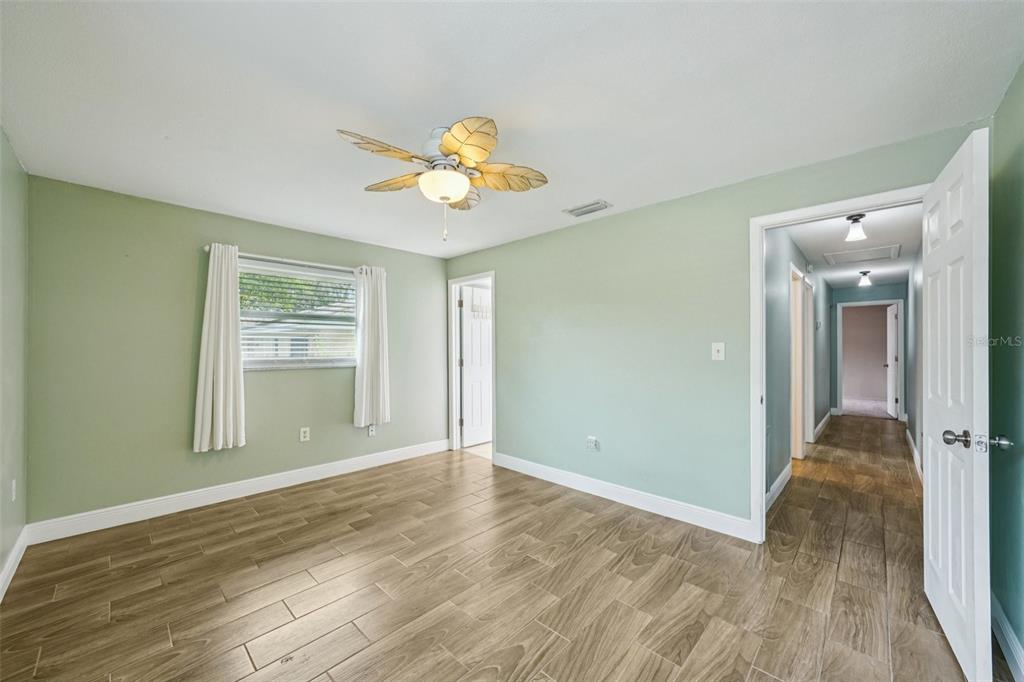1118 Carlton Road Tarpon Springs, FL 34689 - Photo 25 of 62 a view of an empty room with wooden floor and a window