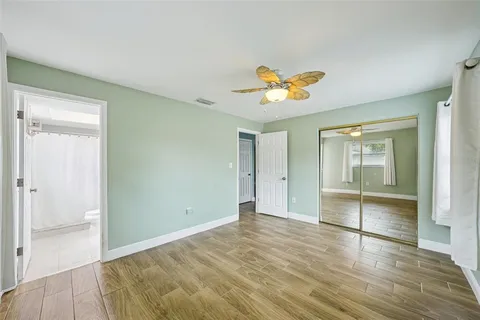 a view of an empty room and chandelier fan