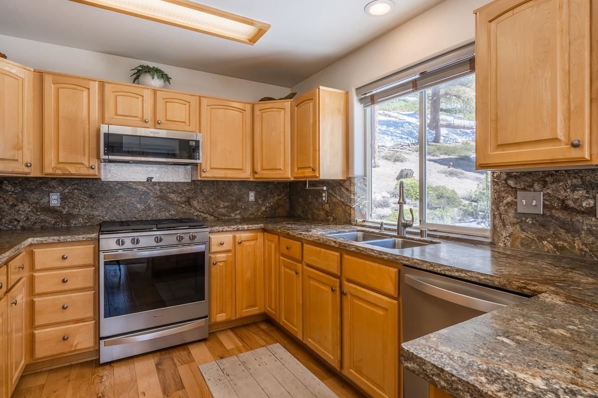 103 Holiday Way Mammoth Lakes, CA 93546 - Photo 11 of 40 a kitchen with stainless steel appliances granite countertop a stove a sink and a microwave