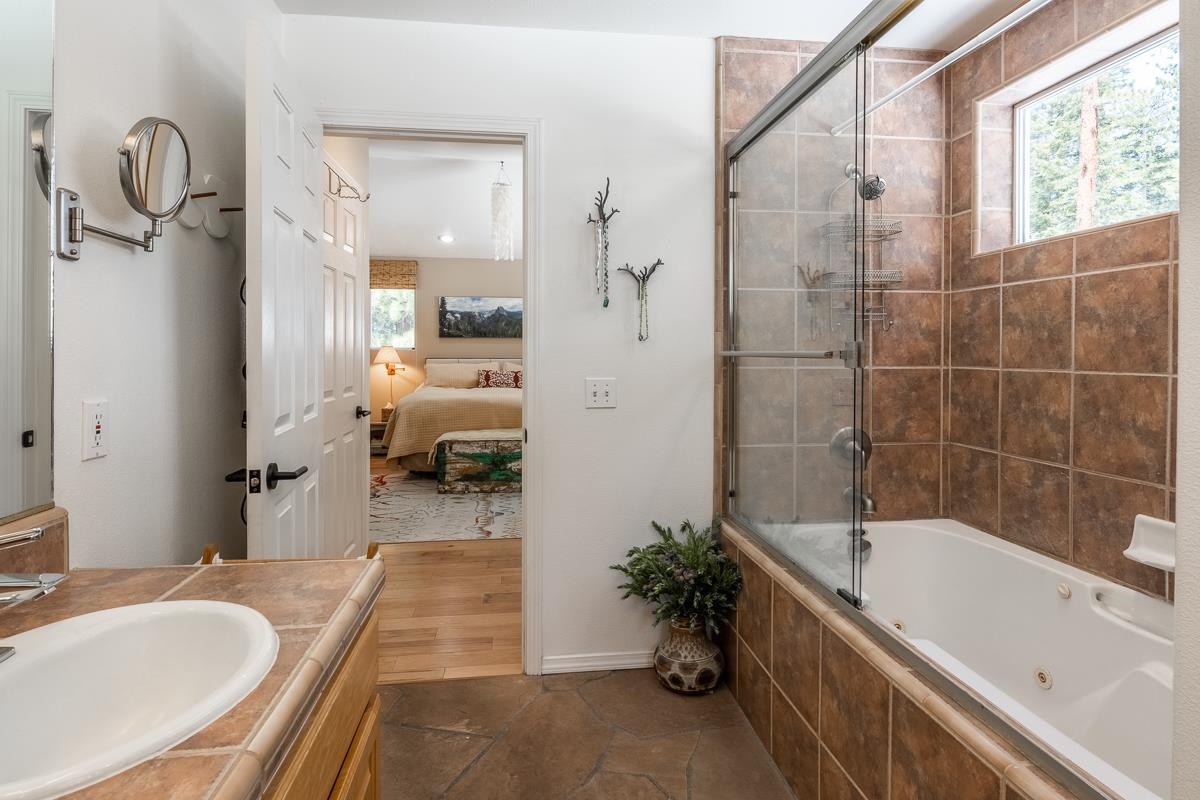 103 Holiday Way Mammoth Lakes, CA 93546 - Photo 23 of 40 a bathroom with a tub sink and mirror
