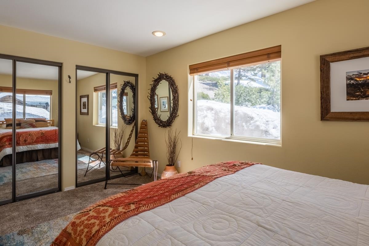 103 Holiday Way Mammoth Lakes, CA 93546 - Photo 25 of 40 a bedroom with a bed a mirror and windows
