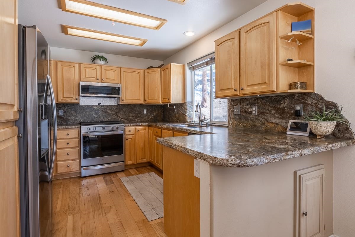 103 Holiday Way Mammoth Lakes, CA 93546 - Photo 10 of 40 a kitchen with stainless steel appliances granite countertop a stove a sink and a microwave