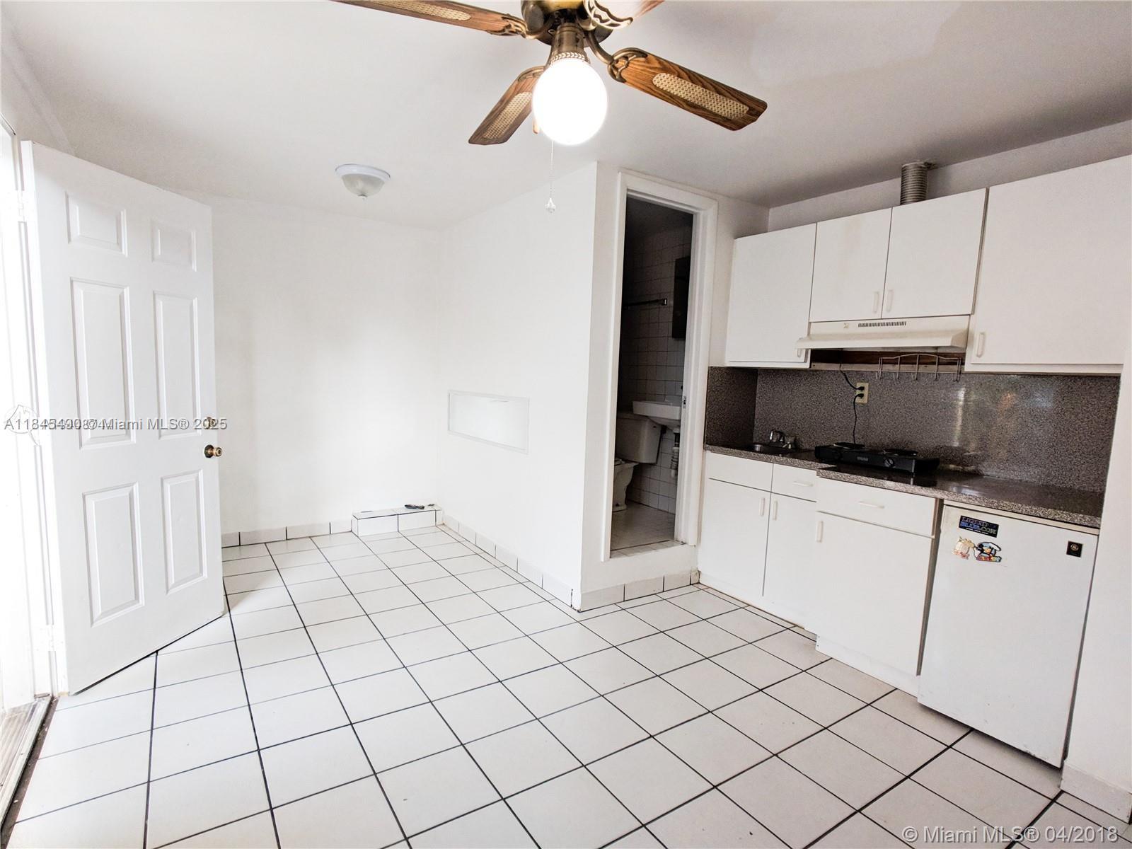 2433 Southwest 11th Street, Unit B Miami, FL 33135 - Photo 7 of 8 a kitchen with white cabinets a sink and appliances