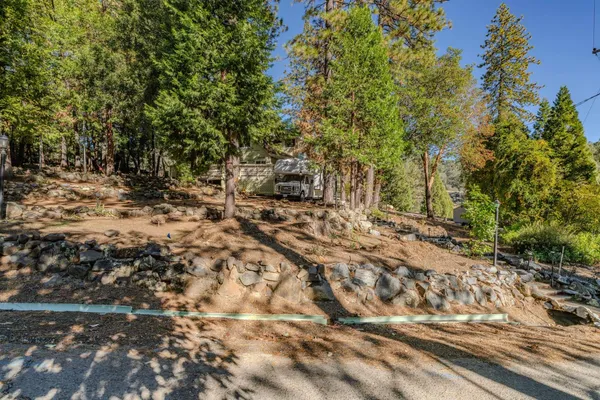 an aerial view of residential house with outdoor space and trees all around