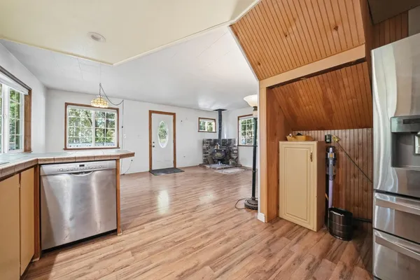 a view of a kitchen with wooden floor and a refrigerator