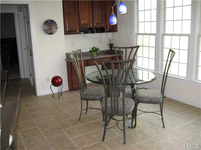 1008 Clark Ridge Court Raleigh, NC 27613 - Photo 6 of 15 Extended breakfast has continuation of the kitchen's tiled floor and additional cabinetry over the bill desk.