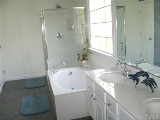 1008 Clark Ridge Court Raleigh, NC 27613 - Photo 8 of 15 Tiled Master Bath has a spa-like escapist feeling with its high vaulted ceiling with a skylight, jetted garden tub for soaking, separate shower and its extended two sink vanity.