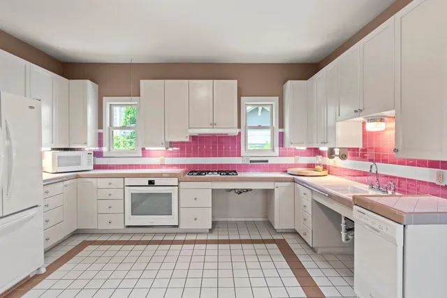 a kitchen with a sink stove top oven and refrigerator