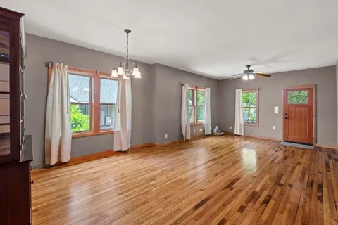 a view of a room with window wooden floor and front door