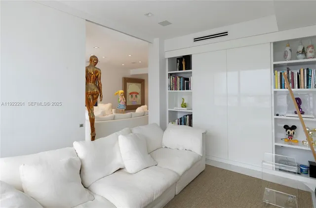 a living room with furniture and a book shelf