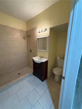 a bathroom with a granite countertop sink a toilet and shower