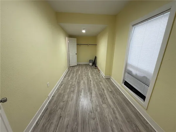 a view of a room with wooden floor and a window